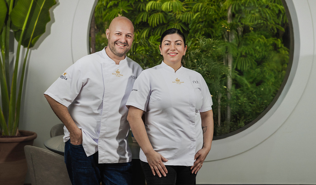 Deux chefs souriants en uniformes blancs devant un jardin à Tenerife.