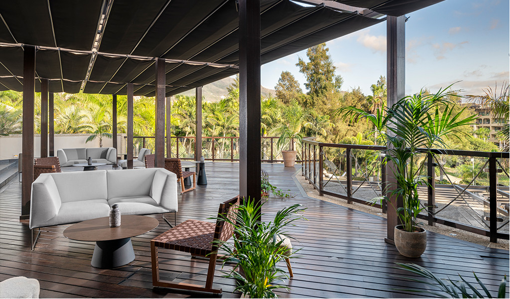 Terrasse avec mobilier d’extérieur entourée de plantes tropicales à Tenerife.