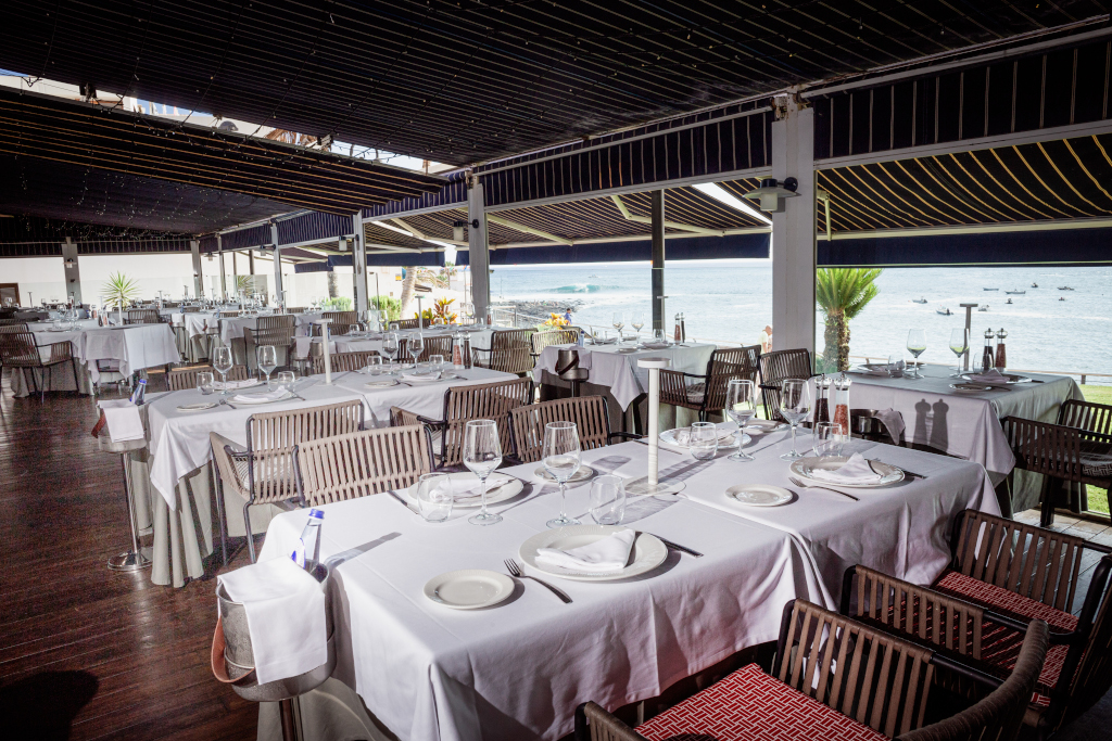 Restaurant avec des tables préparées en face de la mer à Tenerife.