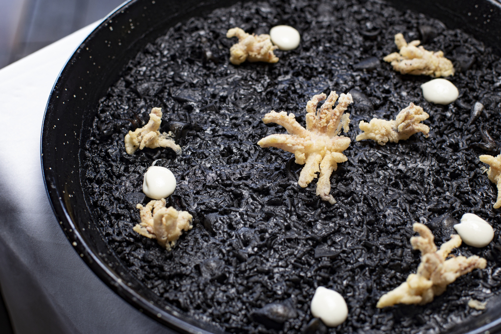 Riz noir avec calmar et aïoli, servi dans une assiette à Tenerife.