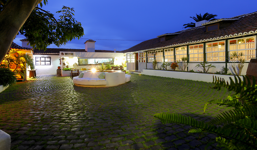 Cour éclairée d’une maison traditionnelle à Tenerife au crépuscule.
