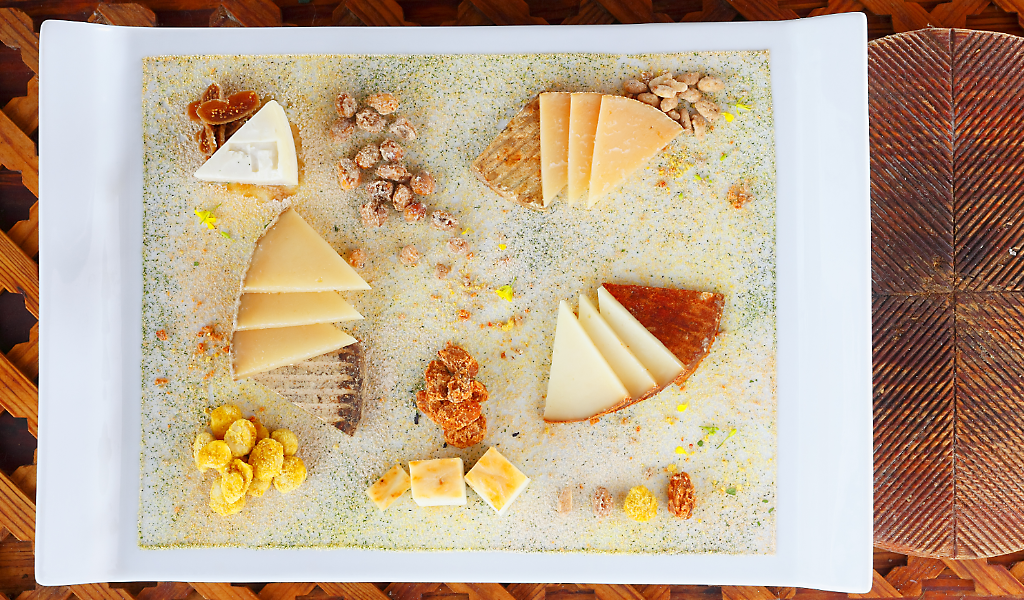 Une variété de fromages dans une assiette à Tenerife, accompagnés de noix et de maïs.