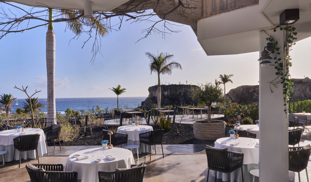 Terrasse de restaurant avec vue sur la mer et palmiers à Tenerife.