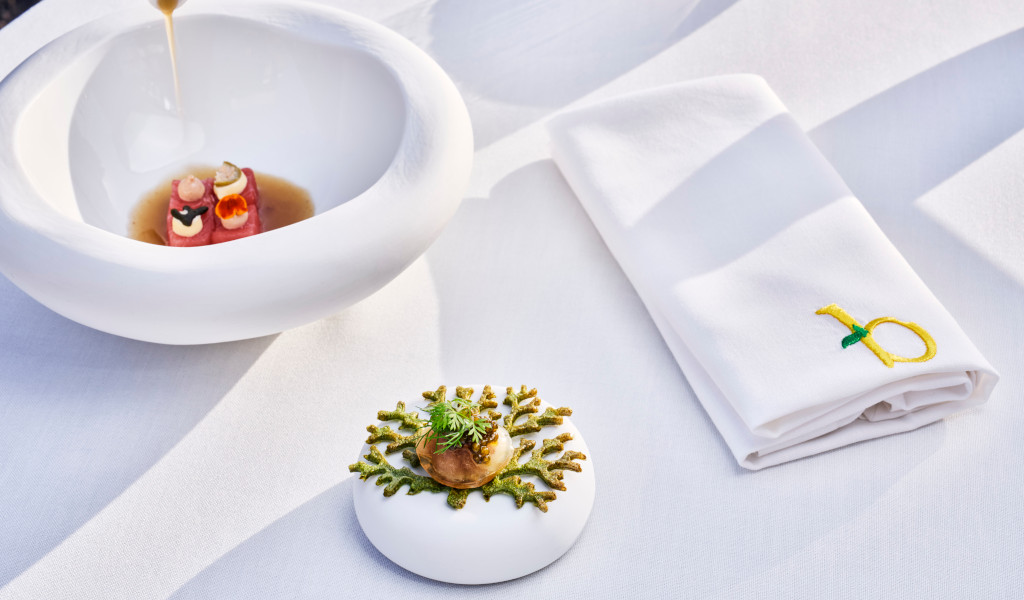 Plat gastronomique avec sauce et serviette brodée dans un restaurant à Tenerife.