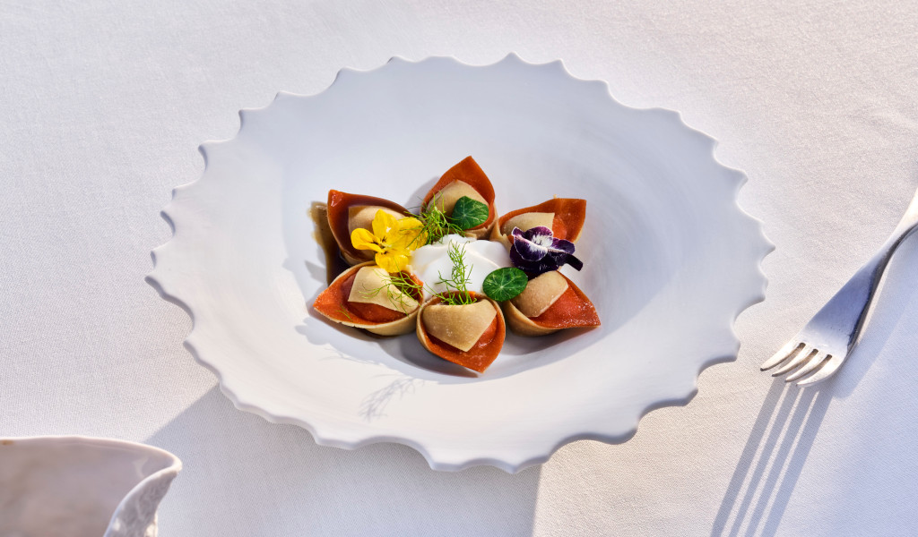 Plat gastronomique décoré de fleurs et d’herbes sur une table de restaurant à Tenerife.