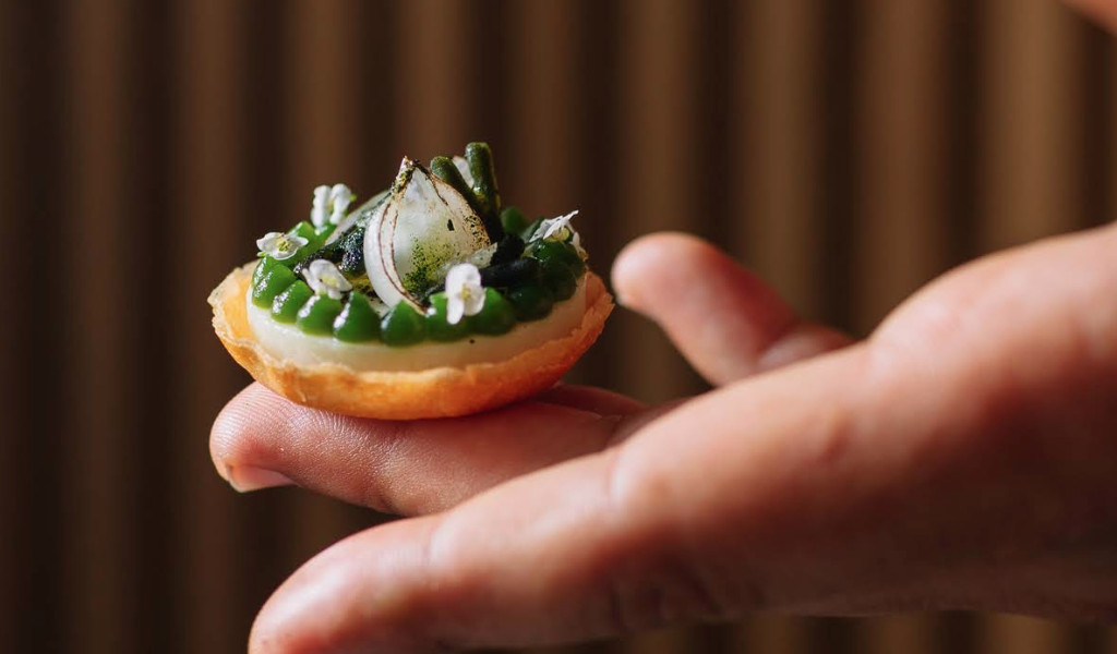 Bouchée gastronomique en main, décorée d’oignons marinés et d’herbes à Tenerife.