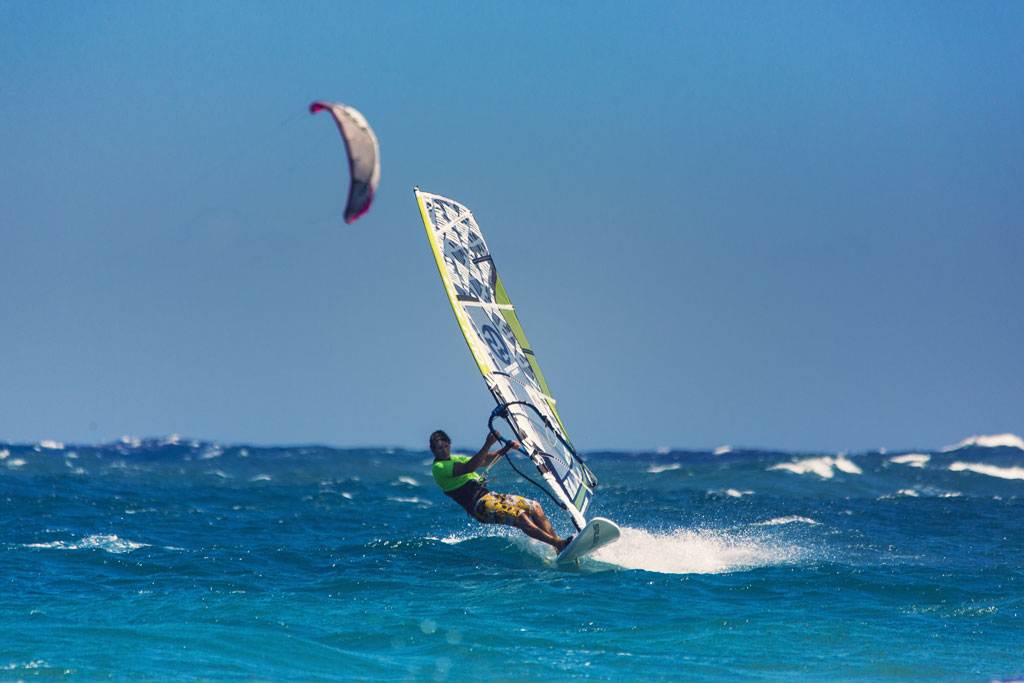 Surfeur faisant de la planche à voile dans la mer de Tenerife sous un ciel dégagé.