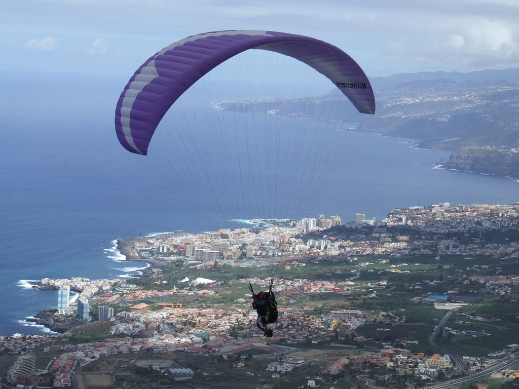 Parapente survolant la côte de Tenerife avec l’océan Atlantique en arrière-plan.