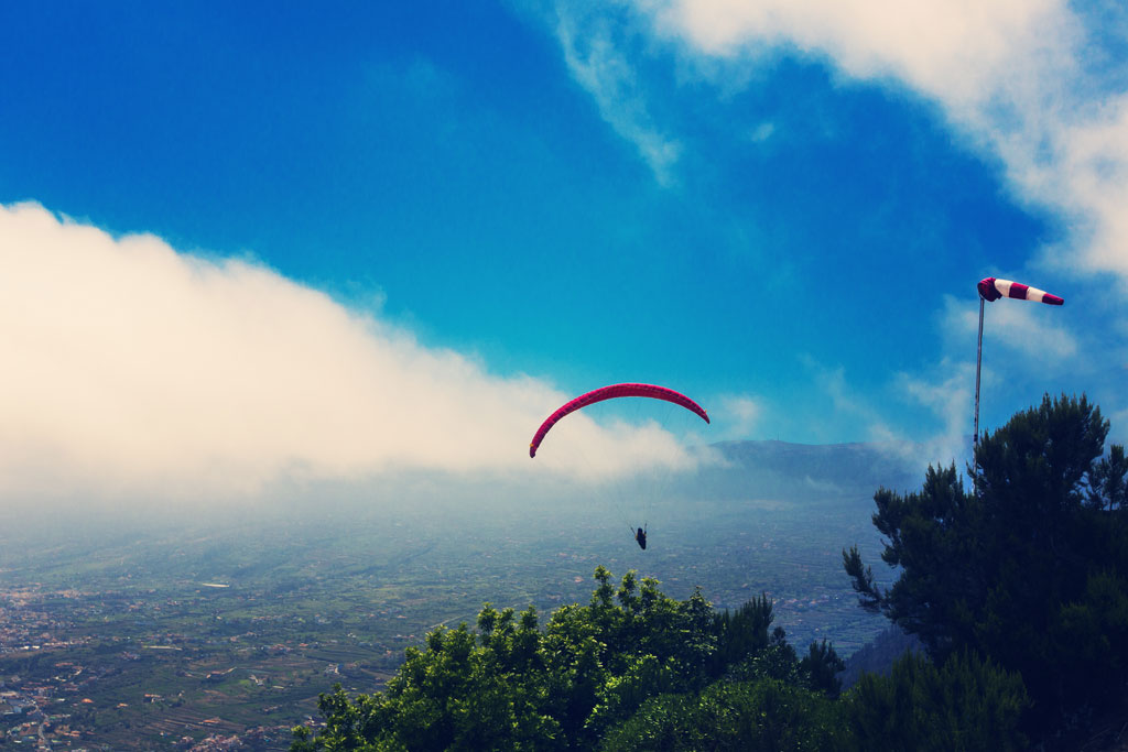 Parapente dans le ciel de Tenerife au-dessus d’un paysage montagneux ?