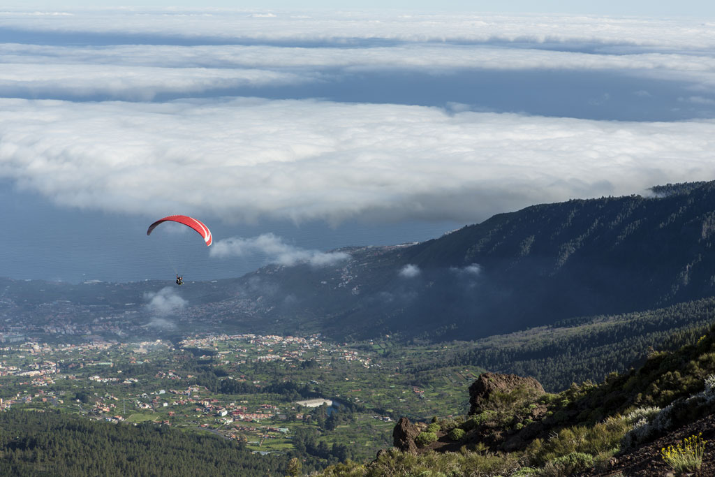 Parapente survolant la vallée de Tenerife avec de faibles nuages.