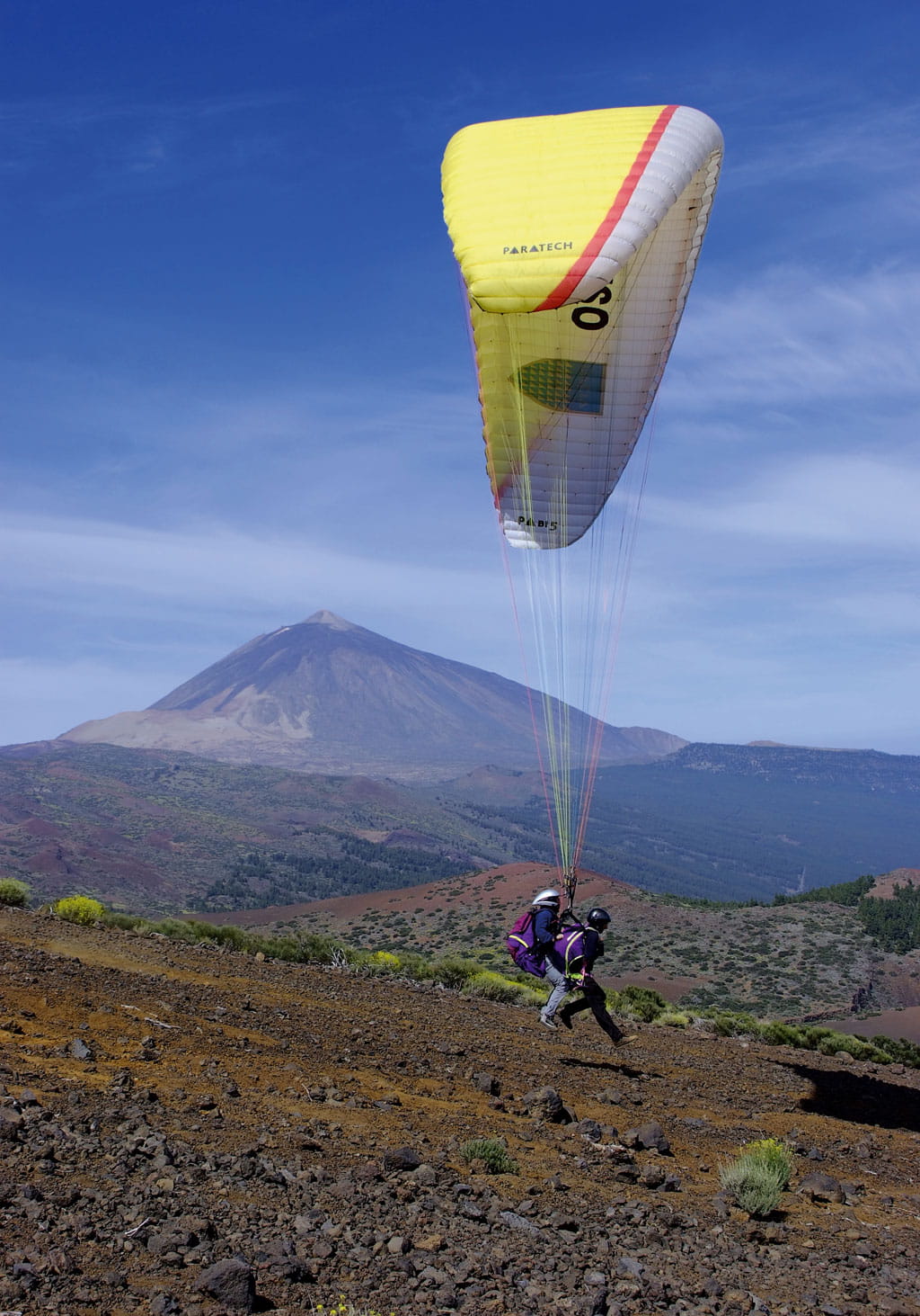 Parapente au-dessus du paysage de la Teide à Tenerife avec deux pilotes.