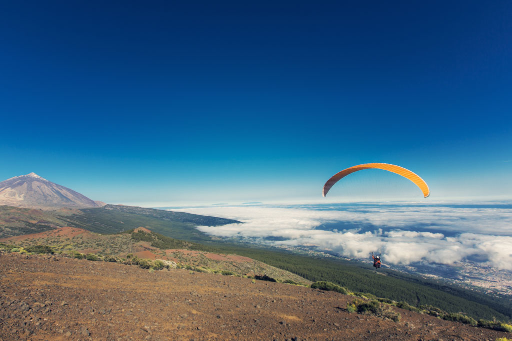 Parapente volant près du mont Teide à Tenerife sous un ciel dégagé.