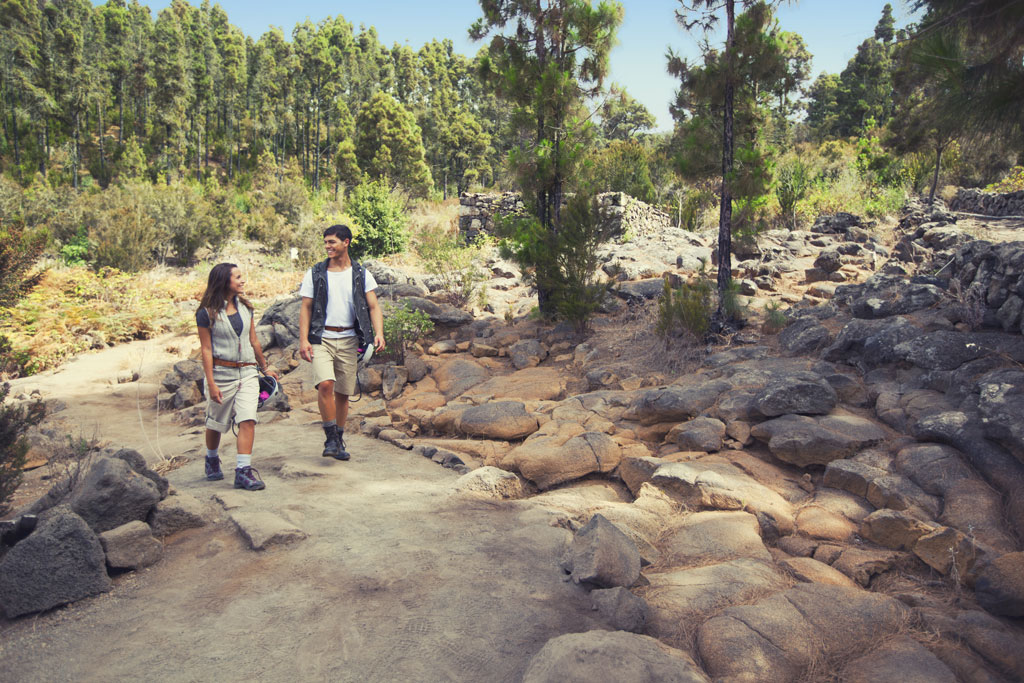 Un couple marchant sur un sentier rocheux dans la forêt de Tenerife.