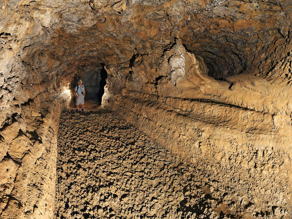 Personne explorant une grotte volcanique à Tenerife.
