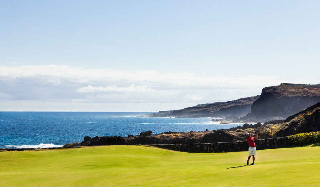 Personne jouant au golf près de la côte à Tenerife avec la mer en arrière-plan.