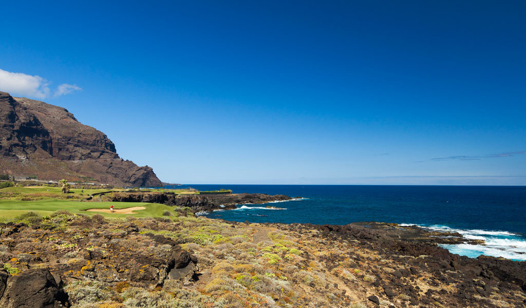 Côte rocheuse et parcours de golf avec l’océan en arrière-plan à Tenerife.