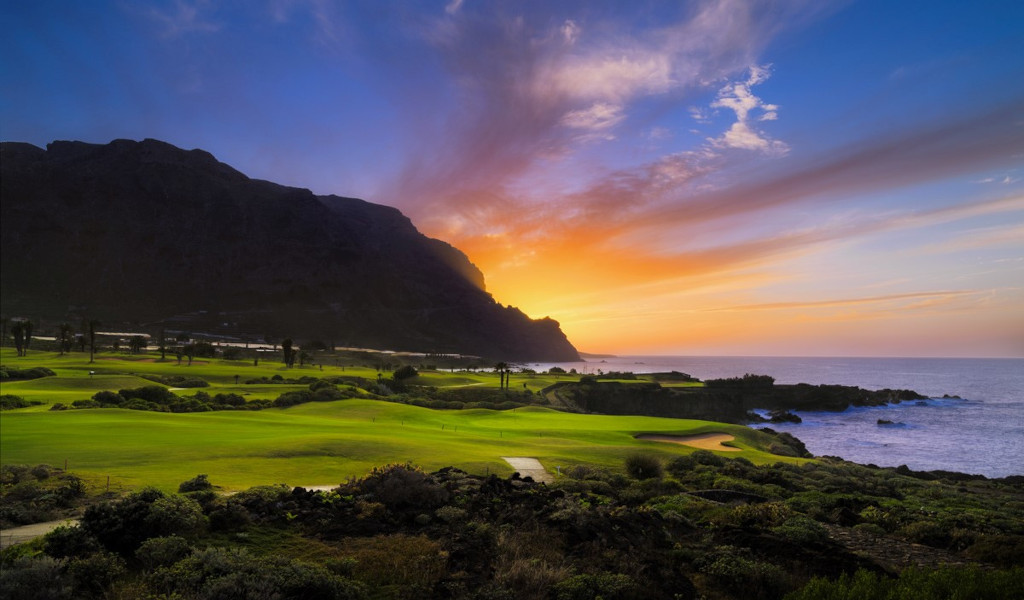 Coucher de soleil au-dessus d’un parcours de golf à Tenerife au bord de la mer.