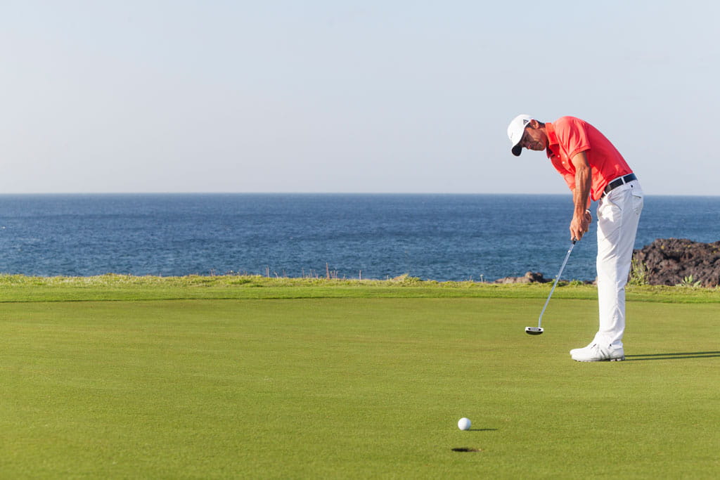Personne jouant au golf au bord de la mer à Tenerife.