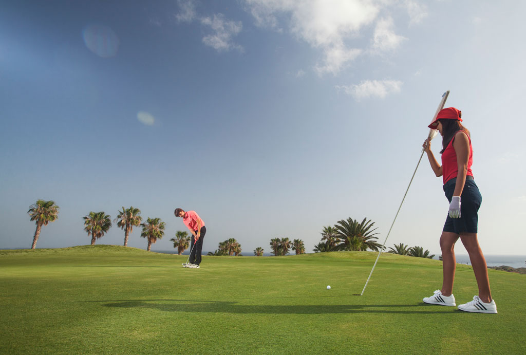 Des golfeurs sur le parcours bordé de palmiers à Tenerife.