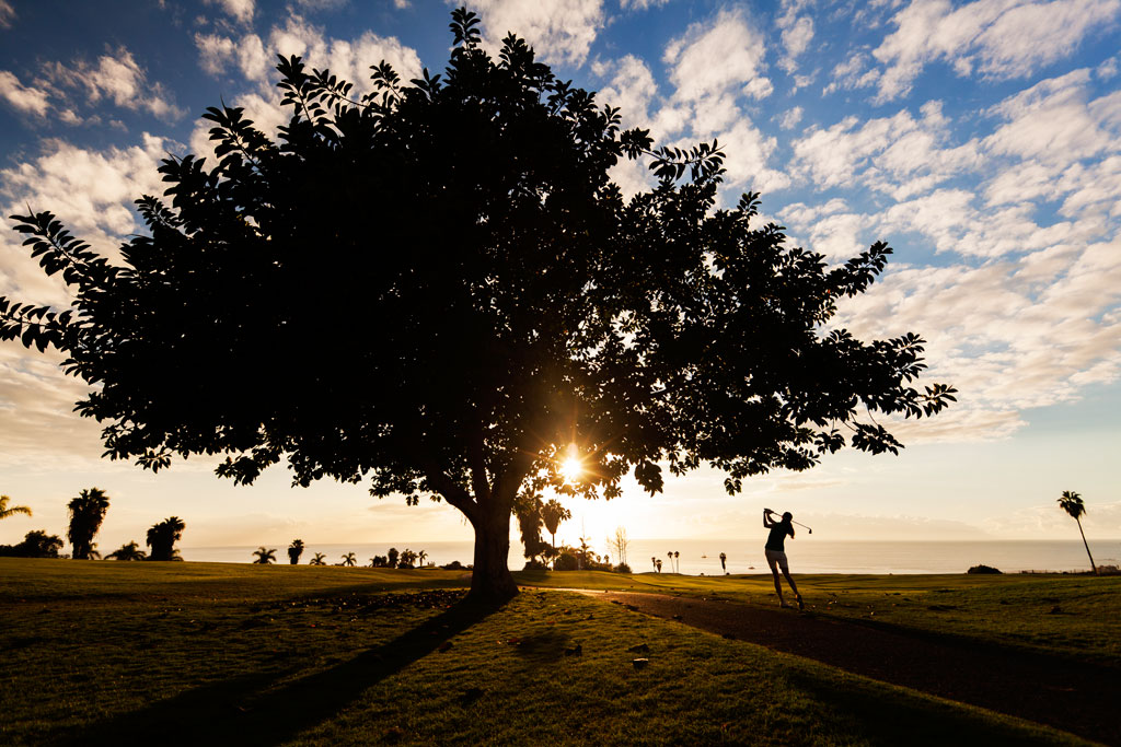 Personne jouant au golf au coucher du soleil sur un parcours à Tenerife.