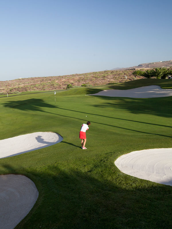 Joueur de golf sur le parcours Abama à Tenerife, près du trou et d’un bunker.