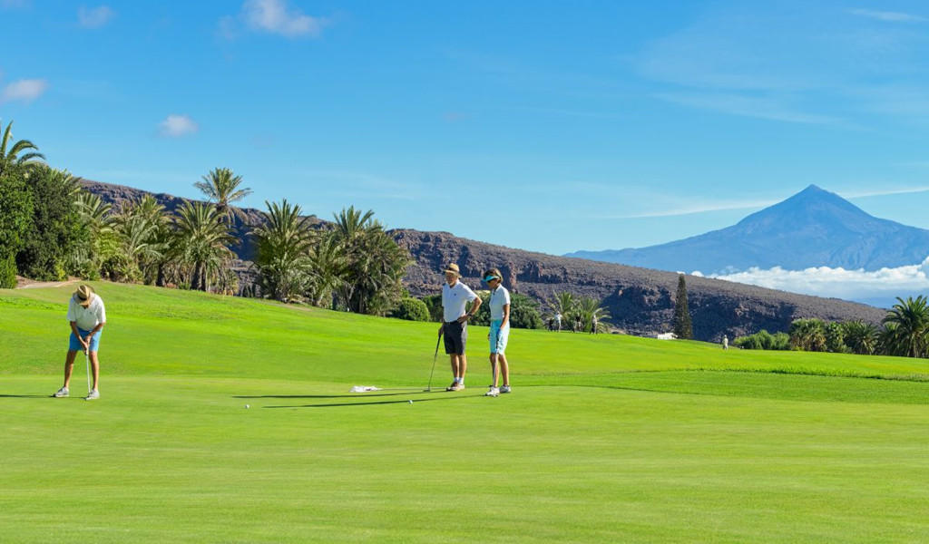Des golfeurs sur un parcours à Tenerife avec le mont Teide en arrière-plan.