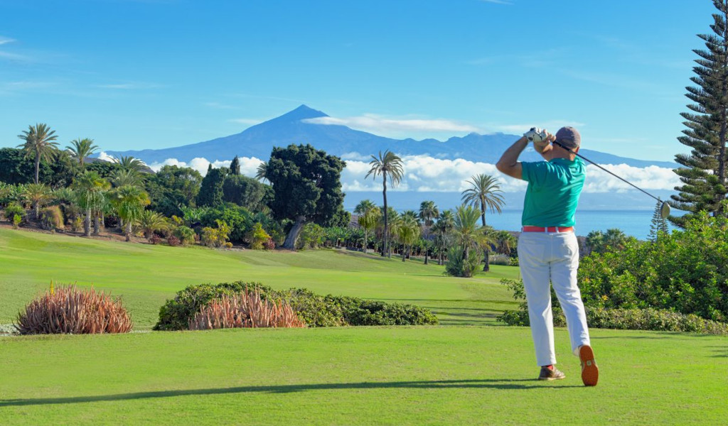 Golfeur en action avec le mont Teide en arrière-plan à Tenerife.