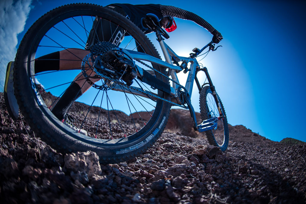 Cycliste de VTT sur un terrain rocailleux à Tenerife sous un ciel bleu.