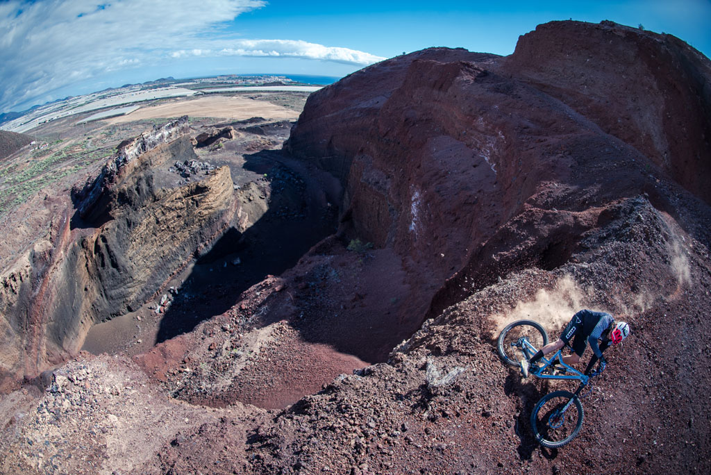 Cycliste descendant une colline dans une carrière à Tenerife, surplombant la mer.