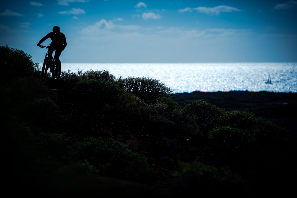 Cycliste sur un sentier côtier avec vue sur la mer à Tenerife.