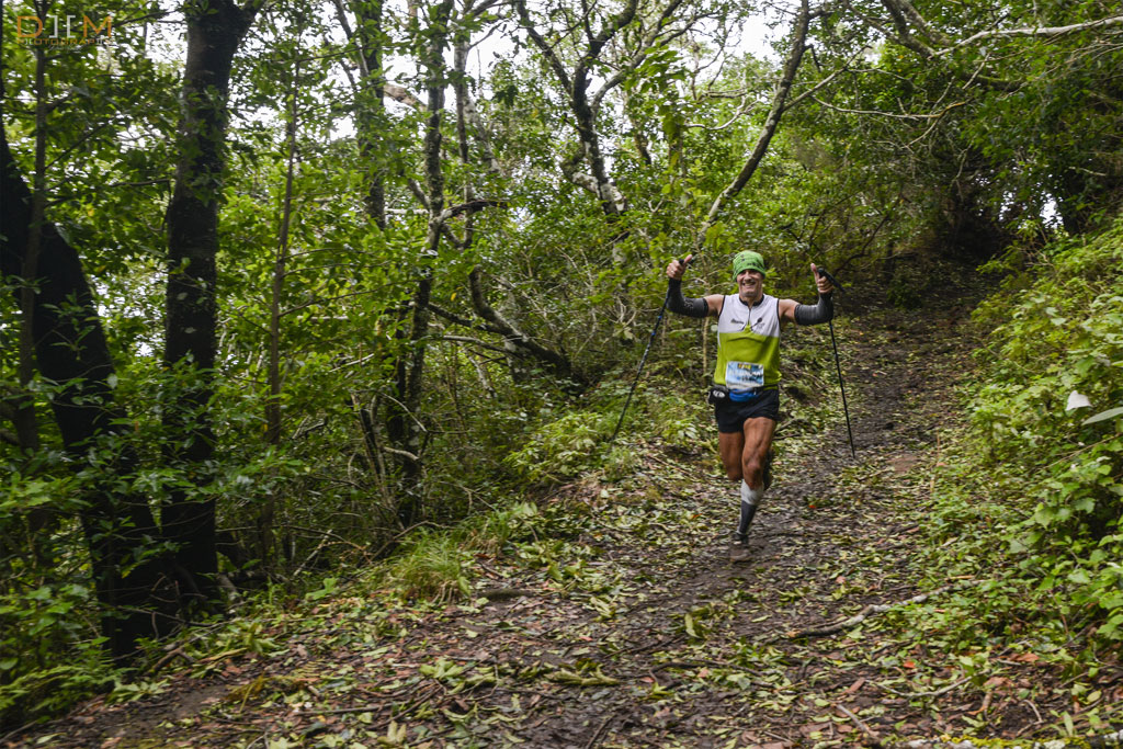 Coureur avec des bâtons sur le sentier boisé de Tenerife.