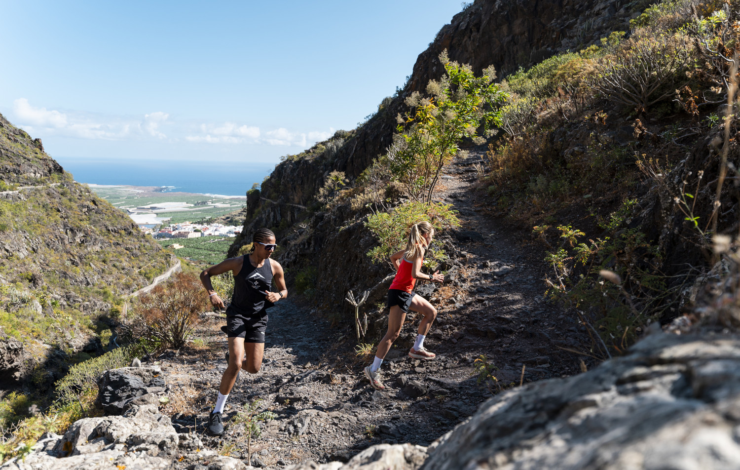 Des coureurs sur une pente rocheuse surplombant la mer à Tenerife.