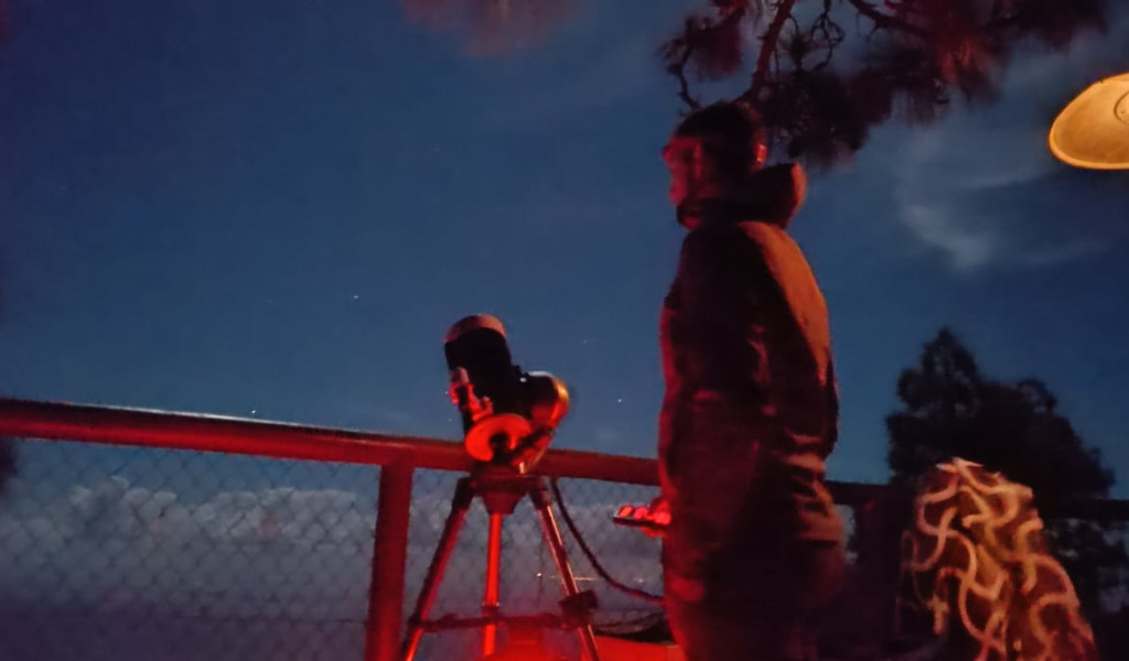 Personne observant le ciel nocturne avec un télescope, possiblement à Tenerife.