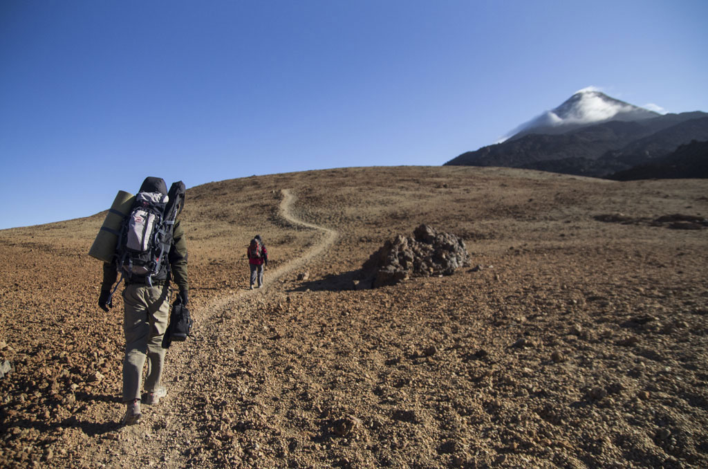 Sentier vers le mont Teide à Tenerife avec deux randonneurs à pied.