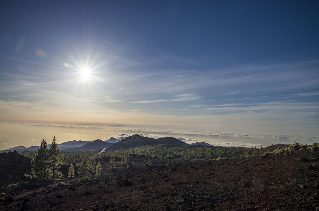 Paysage montagneux du parc national du Teide avec un ciel dégagé et un soleil éclatant.