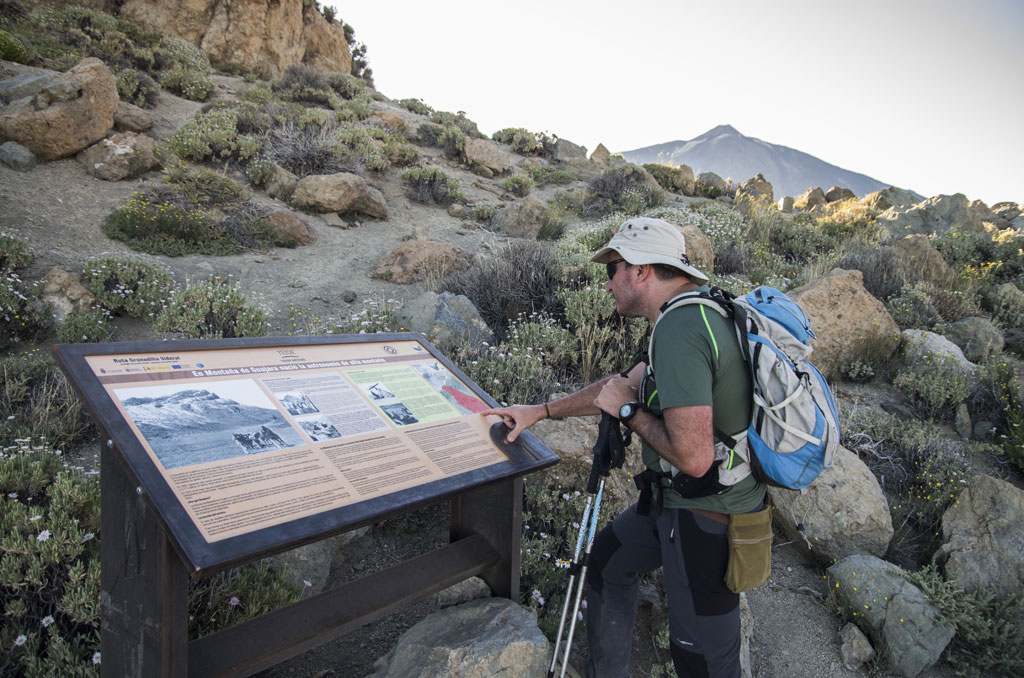 Un randonneur lit un panneau d’information sur le parc national de la Teide à Tenerife.