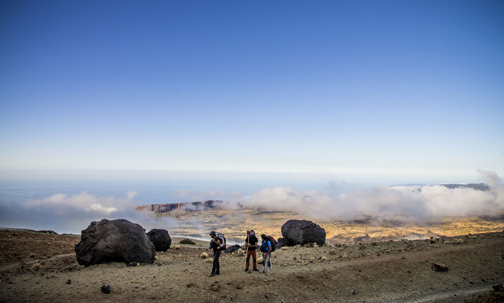 Des randonneurs dans un paysage volcanique avec des nuages à Tenerife.