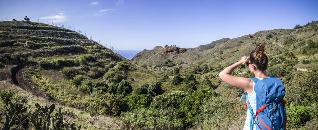 Une personne avec un sac à dos observe le paysage montagneux de Tenerife.