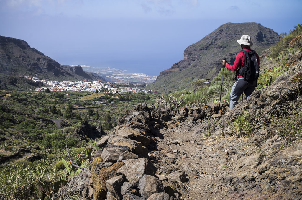 Randonneur avec des bâtons sur un sentier montagneux, vue sur Masca, Tenerife.