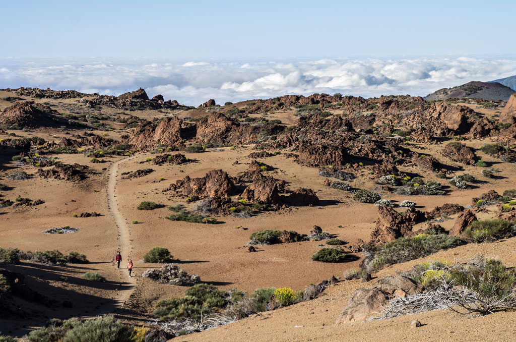 Sentier avec des rochers et deux personnes marchant dans le parc national de la Teide, Tenerife.