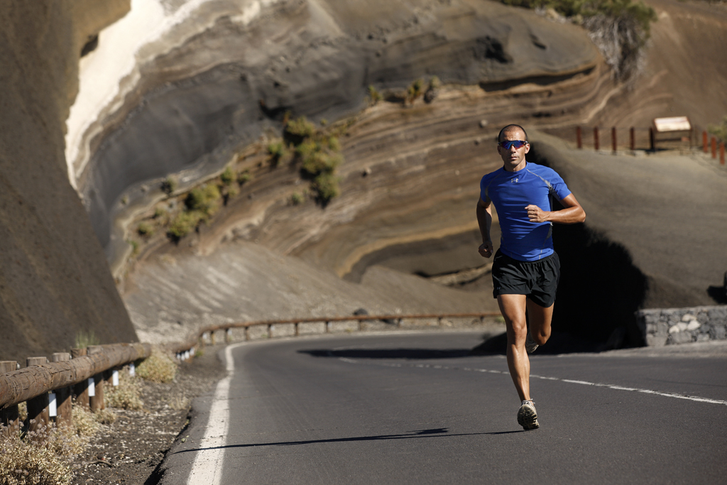 Coureur en t-shirt bleu sur la route de montagne à Tenerife.