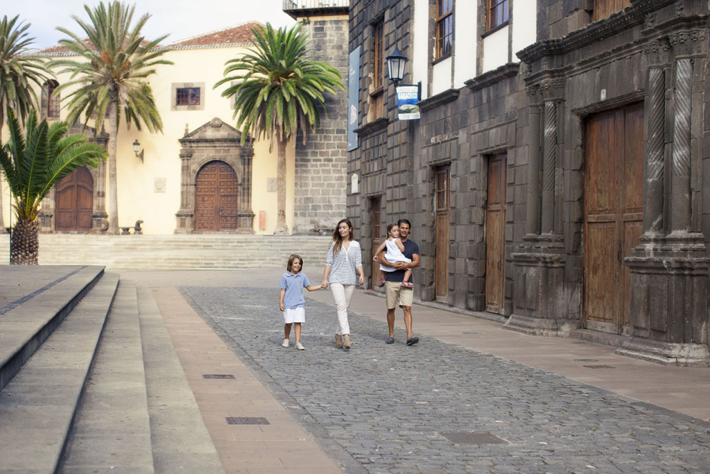 Famille marchant dans la rue avec des bâtiments historiques à La Laguna, Tenerife.