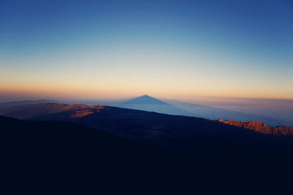 L’ombre du mont Teide projetée sur la mer au coucher du soleil à Tenerife.
