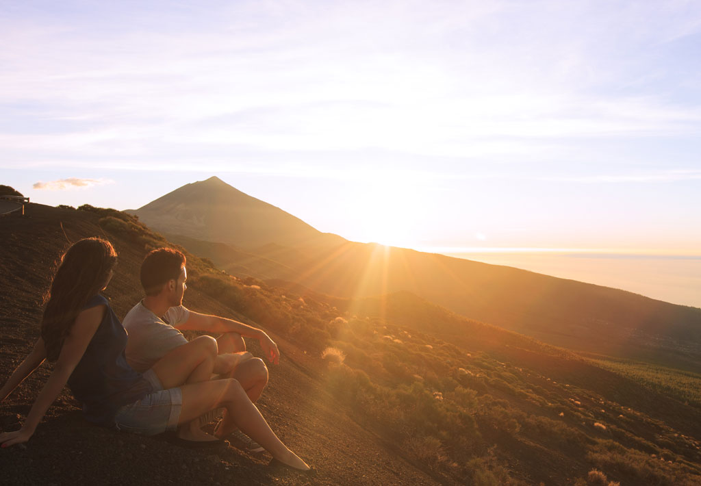 Un couple regardant le coucher de soleil sur le mont Teide, à Tenerife.