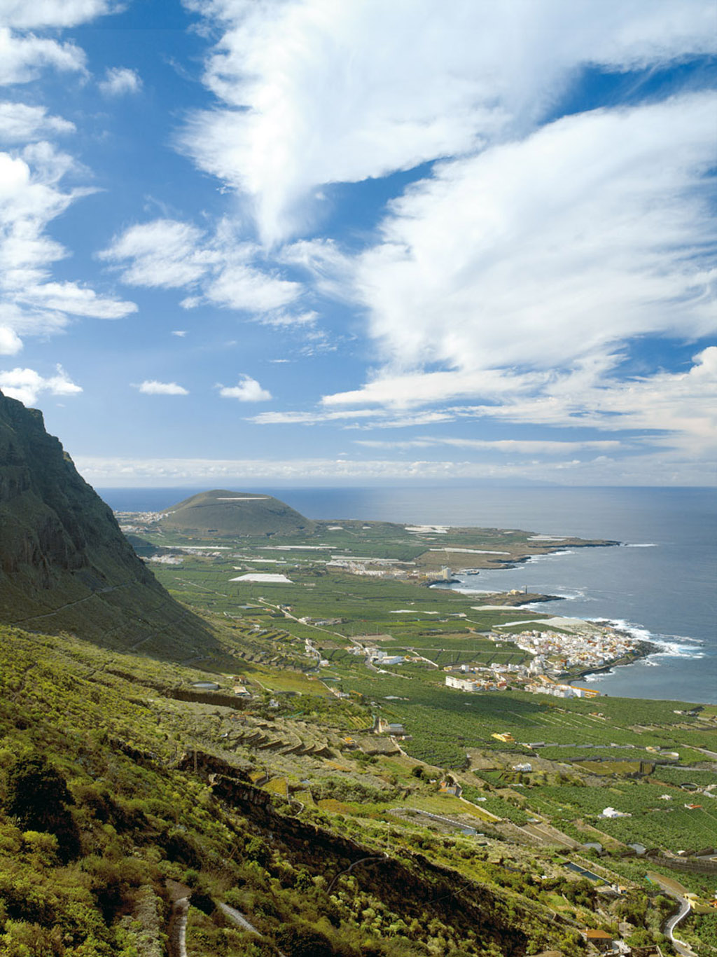 Vue panoramique sur Garachico, Tenerife, avec des montagnes et l’océan Atlantique en arrière-plan.