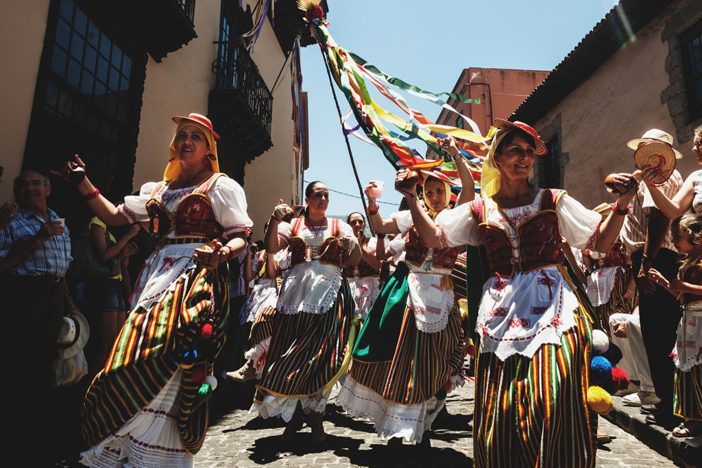 Des personnes en costumes traditionnels dansent dans une rue de Tenerife.