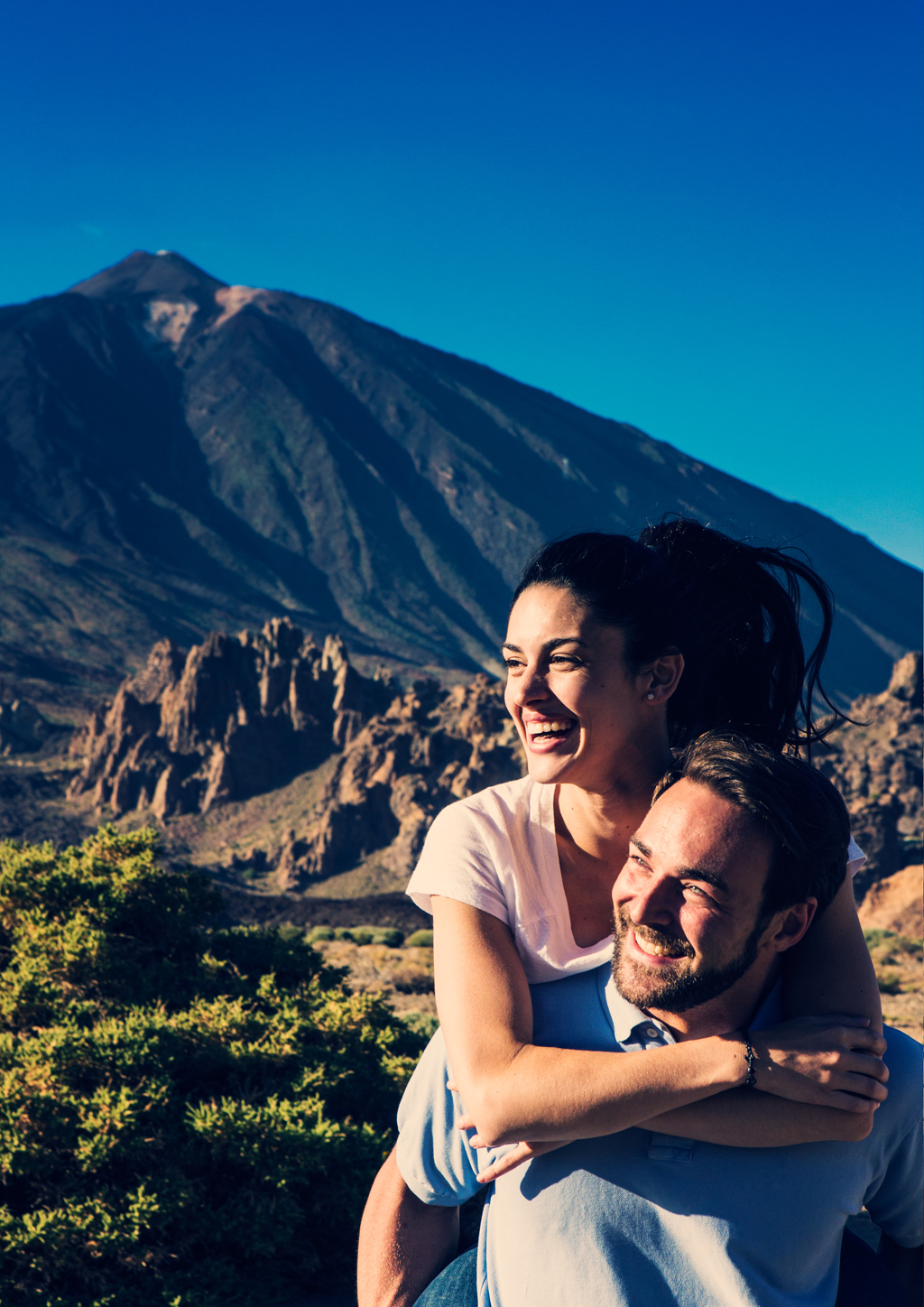 Un couple souriant avec le mont Teide à Tenerife en arrière-plan.