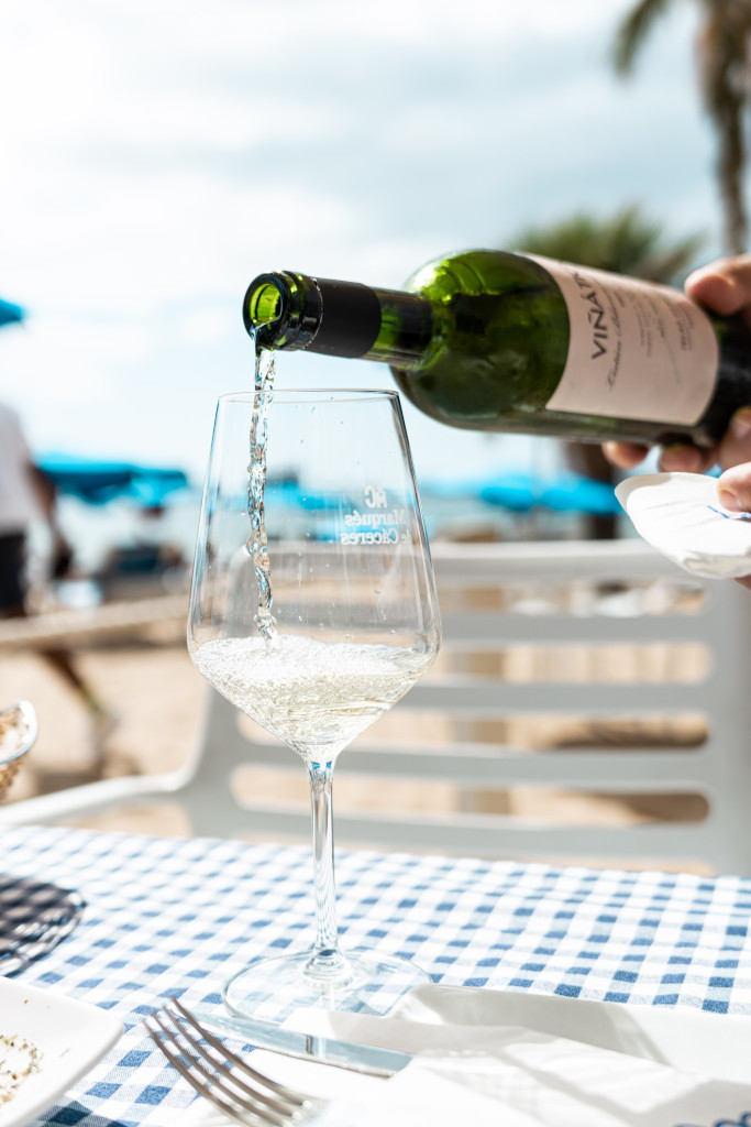 Du vin blanc servi dans un verre sur une table avec une nappe à carreaux à Tenerife.