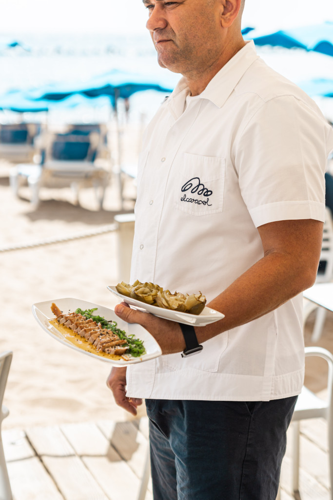 Personne servant des assiettes de nourriture sur une plage à Tenerife.