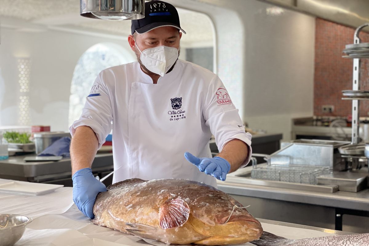 Chef à Tenerife préparant du poisson frais dans la cuisine.